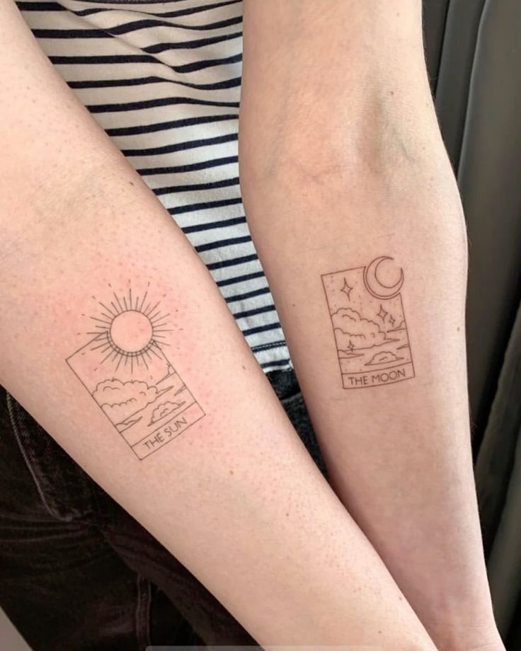 two people with matching tattoos on their arms, one is holding the other's arm