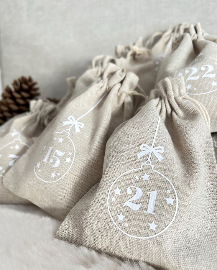 three bags with numbers on them sitting next to a pine cone