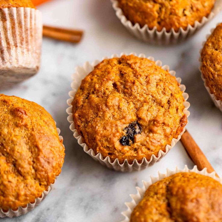 several muffins are sitting on a table with cinnamon sticks