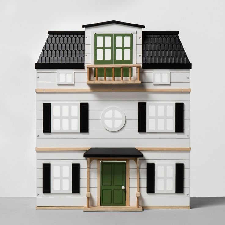 a model house with green doors and windows on the top floor, in front of a white background