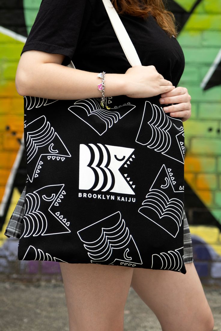 The Brooklyn Kaiju Tote is the perfect everyday bag. Durably crafted from 16oz canvas cotton, this stylish and urban chic tote is designed to provide long-lasting use and protection. The cotton lining ensures that your items remain secure, making it an ideal companion for all your daily tasks. Urban Canvas Bags With Large Capacity, Urban Style Large Capacity Canvas Bags, Casual Cotton Shoulder Bag With Canvas Lining, Large Capacity Canvas Shoulder Bag For Streetwear, Trendy Cotton Canvas Bag With Adjustable Strap, Casual Canvas Bag With Cotton Lining, Casual Cotton Canvas Bag With Canvas Lining, Rectangular Canvas Bags For Streetwear, Cotton Canvas Tote Bag With Adjustable Strap