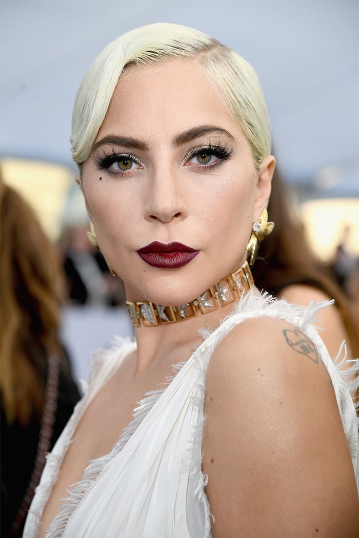 lady in white dress with red lipstick and gold choker