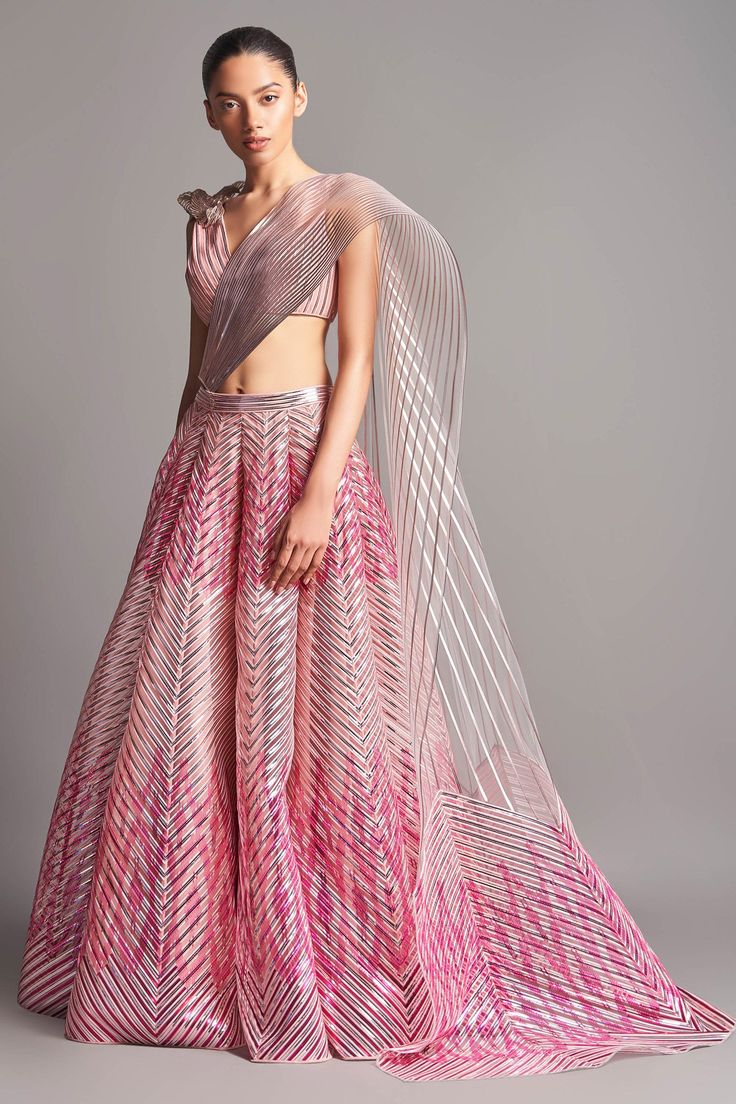 Blush pink structured lehenga with metallic stripes in chevron pattern and winged drape. Comes with corded hand embroidered blouse enhanced with 3D motifs.
Component: 3
Embroidered
Neckline: V Neck
Sleeve Length: Sleeveless
Fabric: Tulle
Color: Pink
Winged drape
Striped and chevron pattern
Closure: Blouse: Back hooks
Note: The dupatta worn by the celebrity is not for sale. - Aza Fashions Metallic Lehenga, Pink Tulle Gown, Amit Aggarwal, Hand Embroidered Blouse, Evening Gowns Elegant, Tulle Gown, Embroidered Neckline, Pink Tulle, Metallic Pink