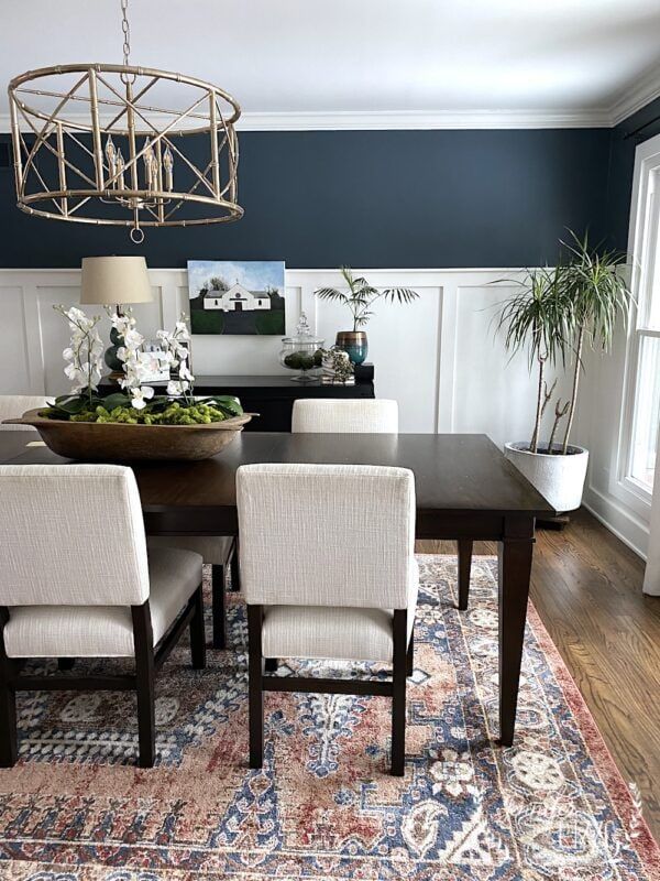 a dining room table with chairs and a rug on the floor