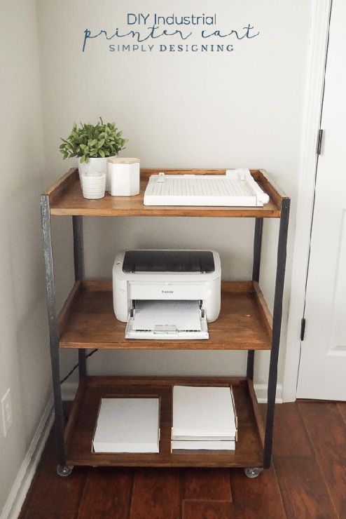 a computer desk with a printer on it and a potted plant next to it