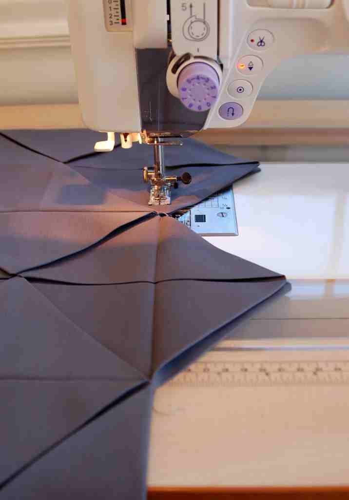 the sewing machine is on top of the quilting material that has been sewn