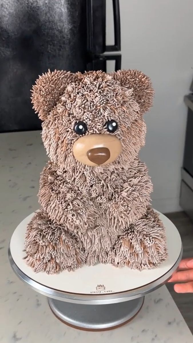 a teddy bear sitting on top of a cake plate