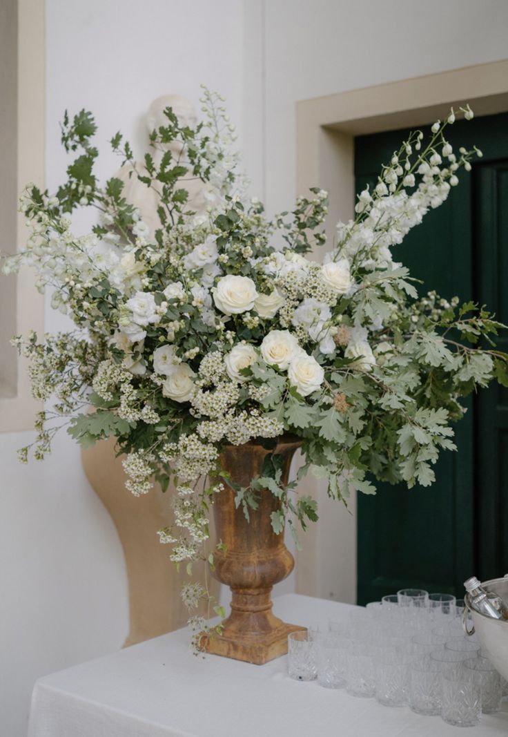 a vase filled with white flowers sitting on top of a table