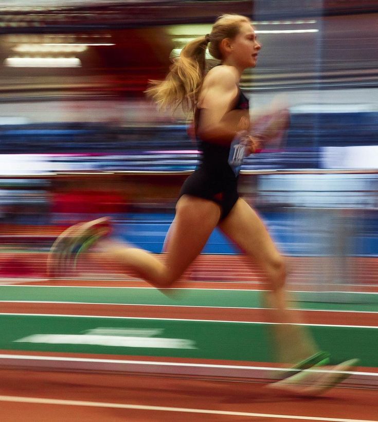 a woman running on a track with blurry background