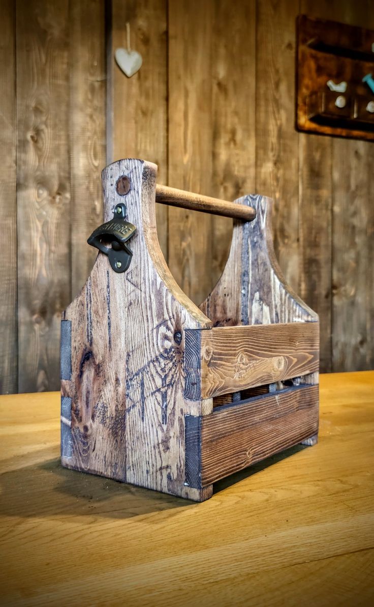 an old wooden tool holder with a hammer sticking out of it's side on a table