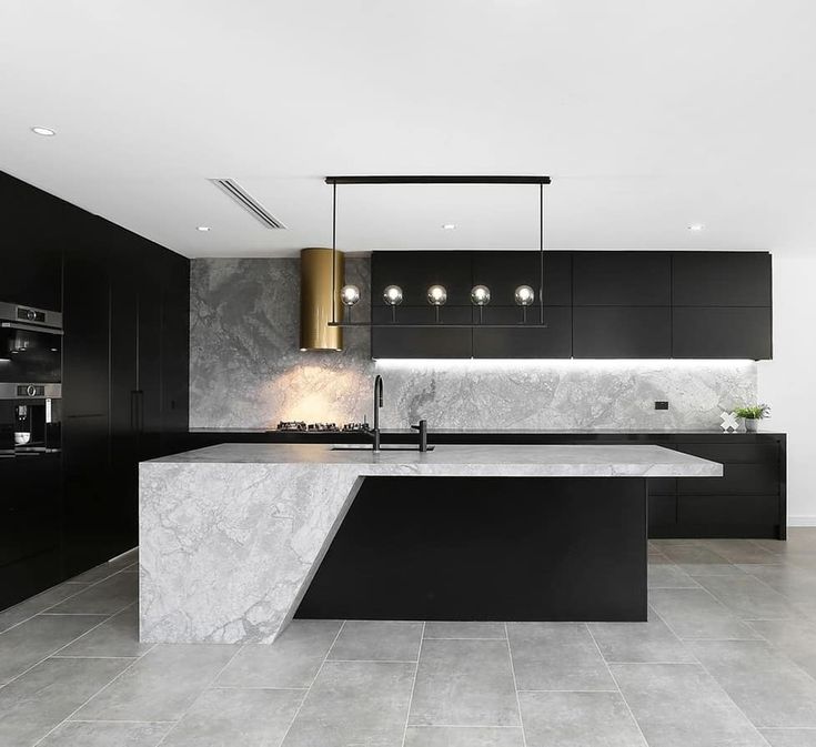 a modern kitchen with marble counter tops and black cabinets, along with an island in the middle