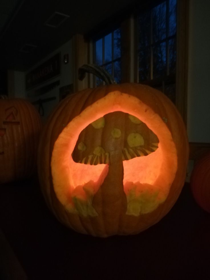 two pumpkins that have been carved to look like mushrooms