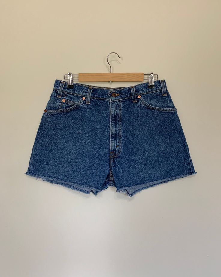 "High waisted 90's denim shorts. Made by Levi's in light dark denim wash. Shorts are in excellent clean condition. Perfectly worn in with light naturally distressed character. These have been cut off and washed once. Measurements are taken zipped or buttoned up and laid comfortably flat then x 2 for total circumference (inches) Levis 550 Tag Size 34 100% Cotton Waist 33\" Hips 45\" Length 14\" Inseam 2.5\" Rise 12.5\" leg opening circumference 25.5\" All items are free of rips, tears, holes, and 90s Style Shorts With Belt Loops, Vintage Dark Wash Denim Shorts, Vintage Jean Shorts With Belt Loops For Summer, Vintage Medium Wash Relaxed Fit Shorts, Vintage Dark Wash Mid-rise Shorts, Vintage High-waisted Dark Wash Jean Shorts, Vintage Dark Wash Jean Shorts For Summer, 90s High Waist Relaxed Fit Shorts, Vintage High Waist Dark Wash Shorts