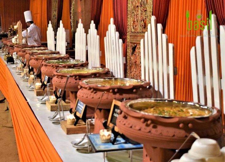 a long table with many bowls of food on it