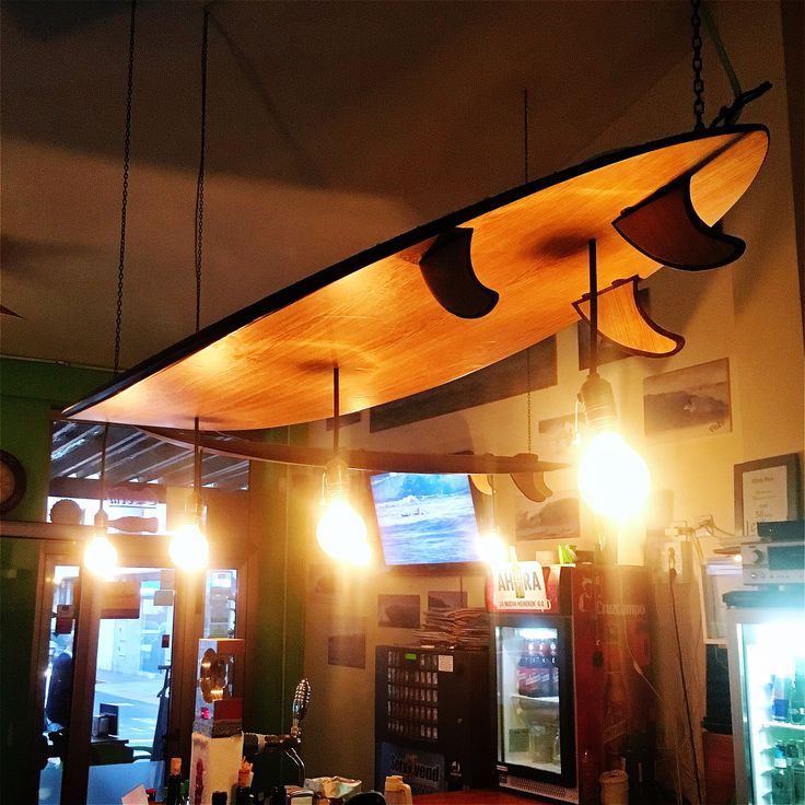 the lights are hanging from the ceiling above the counter in this restaurant, which is decorated with wood planks