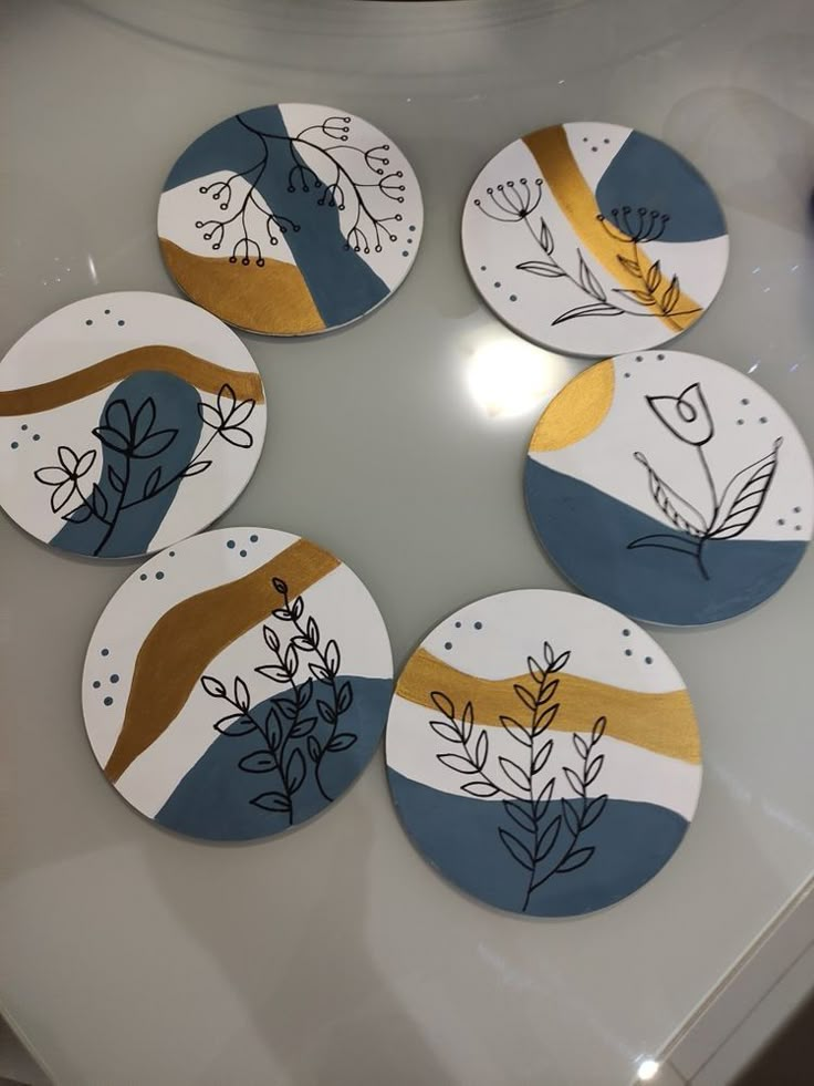 four plates with different designs on them sitting on a white table top in a circle