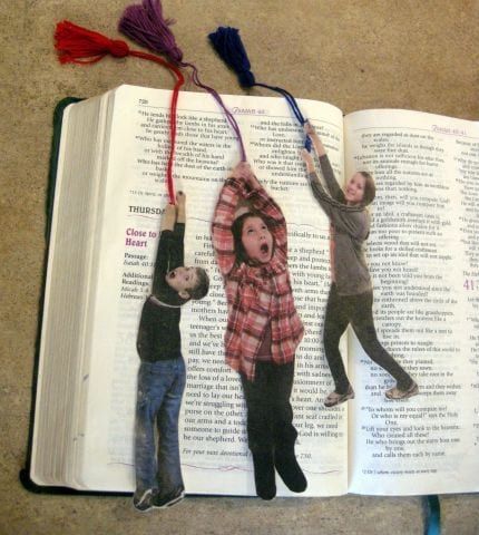 an open book with pictures of people hanging from it