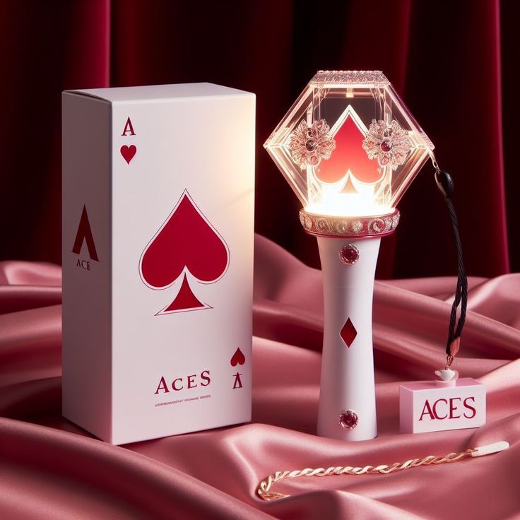 an ace's lamp is sitting next to a box on a pink satin surface