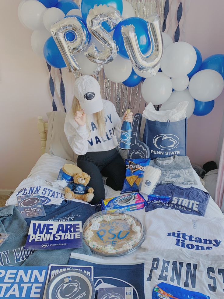 a bed topped with lots of blue and white balloons next to a sign that says usu