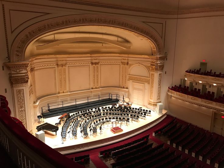 an empty auditorium with rows of seats in the center and lights on either side of the stage