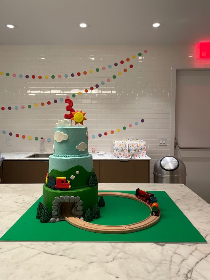 a train themed birthday cake sits on a table