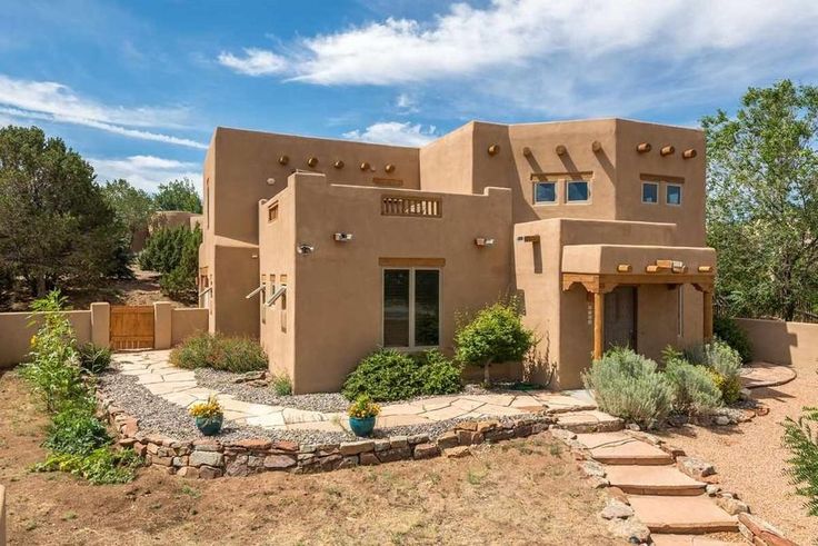 an adobe - style house in the desert with steps leading up to it