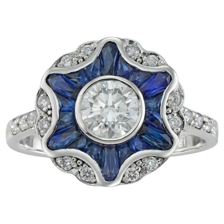 A diamond and sapphire cluster ring, the round brilliant-cut diamond weighing 0.70 carats accompanied by IGL certificate stating to be of H colour and VS2 clarity surrounded by calibre-cut sapphires forming a star, embellished with twelve small round brilliant-cut diamonds set in pairs between six rays, the small diamonds estimated to weigh ¼ of a carat in total, all set in white gold mount with openwork gallery and diamond-set shoulders, finger size N ½ , hallmarked 18ct gold, London, bearing the Bentley & Skinner sponsor mark, measuring approximately 2x1.4cm in diameter, gross weight 3.8 grams. This ring is in excellent condition. A sparkling and colourful ring. This piece features a dazzling central diamond surrounded by a frame of vivid blue sapphires set into the shape of a star and s Sapphire Cluster Ring, Ornate Ring, Geometric Star, Diamond Brooch, Beautiful Engagement Rings, Modern Ring, Sapphire Stone, Diamond Cluster Ring, Diamond Set