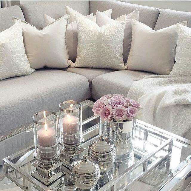 a living room filled with lots of furniture and flowers on top of a glass table