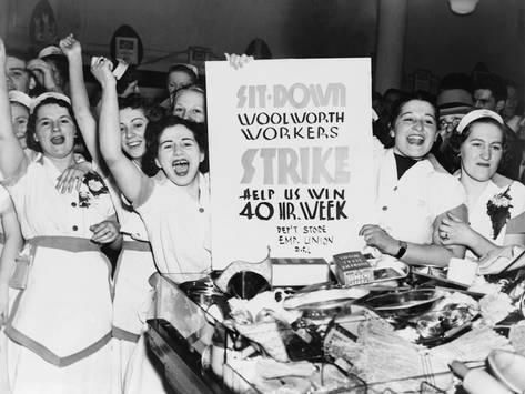 a group of women standing next to each other in front of a sign that says strike