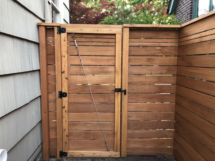 an open wooden gate in the back yard