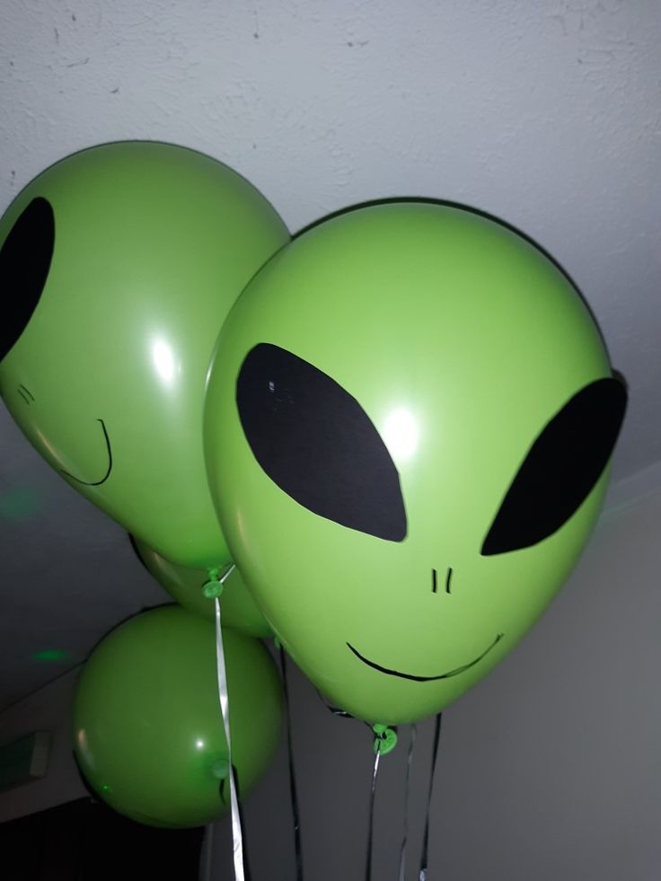 two green balloons with faces on them