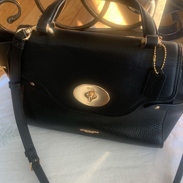 Coach Top Handle / Crossbody Leather Satchel! Carry It In Hand, In The Crook Of Your Arm Or Over The Shoulder For An Incredibly Luxe Look And Plenty Of "Where Did You Get That Bag?". Nwot And No Calls Outs On This Bag ! Shiny Gold Hardware! 4 Bottom Feet. Genuine Leather, Color: Black, Inside Multifunction Pockets; Fabric Lining Turnlock And Zip Closures; Top Handle With 4.75" Drop Detachable Strap With 22.5" Drop For Shoulder Or Crossbody Wear Approximate Dimensions: 9.5 'L 8.5 H 5.25'w Smooth Black Satchel For Work With Turn-lock Closure, Formal Black Satchel With Cc Turnlock Closure, Black Satchel With Cc Turnlock Closure For Travel, Elegant Black Satchel With Cc Turnlock Closure, Black Satchel With Cc Turnlock Closure, Leather Satchel, Gold Hardware, Pebbled Leather, Coach Bags