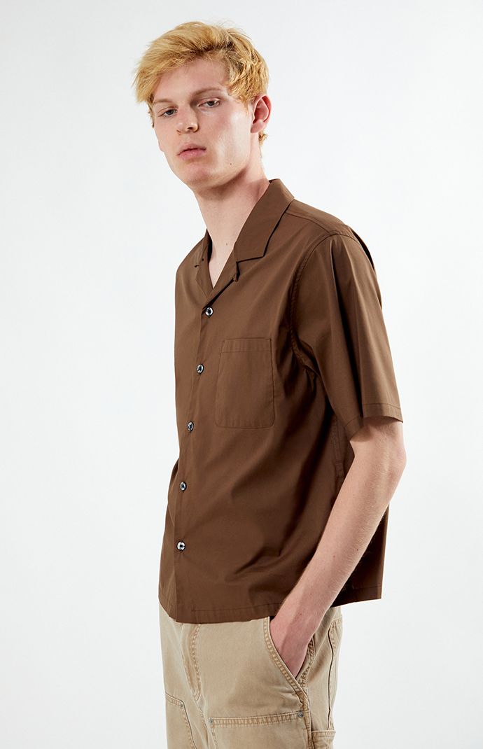 Unwind in style with PacSun's Solid Oversized Camp Shirt. Boasting a laid-back vibe with its collared neckline, short sleeves, and relaxed fit, this shirt is perfect for casual outings. Complete with a left chest pocket for added convenience, it's a versatile wardrobe staple for easy, breezy days.


	Collared neckline
	Short sleeves
	Oversized fit
	Button closures
	Left chest pocket
	69% cotton, 26% nylon, 5% spandex
	Machine washable
	Model is wearing size medium
	Model Measurements: 6’3”  Height, 28” Waist, 33.5” Hips Summer Collared Short Sleeve Shirt With Pockets, Relaxed Fit Camp Shirt With Button Closure, Casual Brown Top With Johnny Collar, Casual Brown Johnny Collar Top, Summer Shirt With Short Sleeves And Pockets, Summer Shirt With Pockets And Collared Neckline, Summer Shirt With Lapel Collar And Button Closure, Summer Short Sleeve Shirt With Lapel Collar And Pockets, Summer Short Sleeve Shirt With Pockets And Lapel Collar