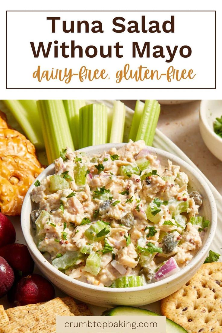 tuna salad in a bowl with crackers, grapes and celery on the side