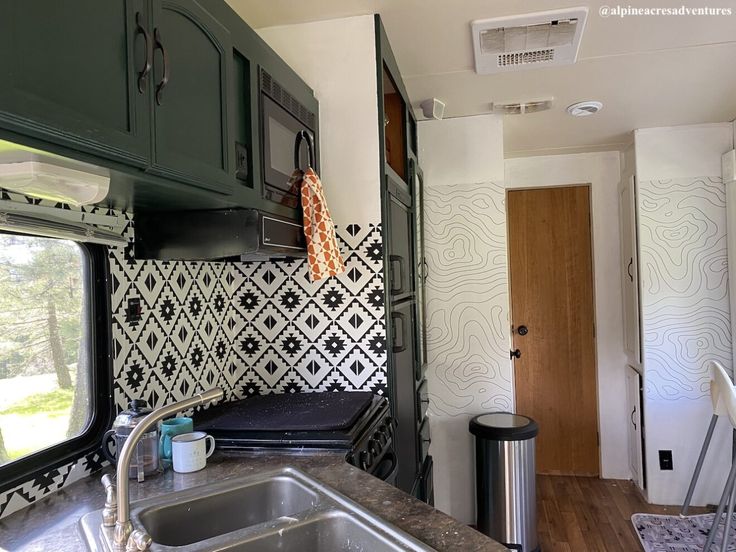 a kitchen area with sink, stove and cabinets