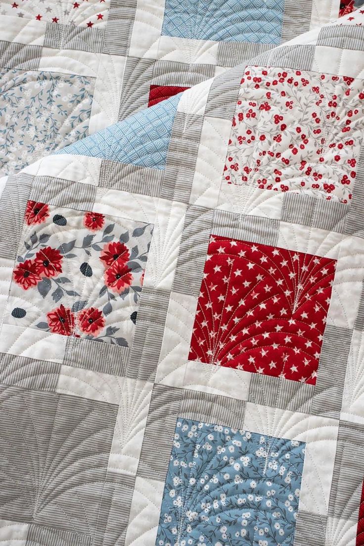 a close up of a quilt with red, white and blue flowers on it's edges