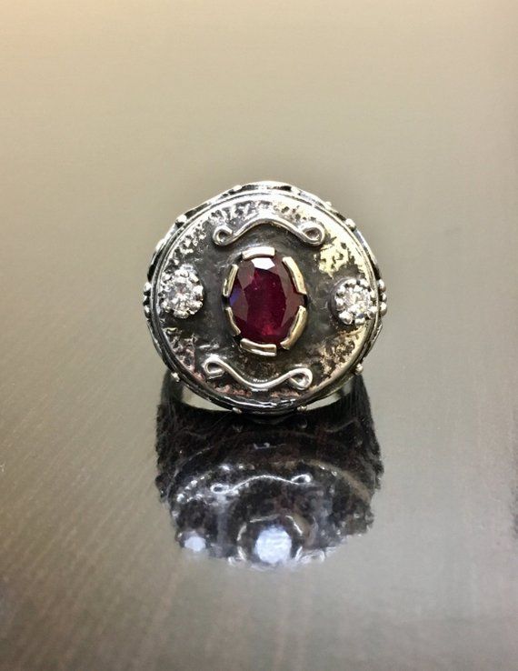 DeKara Designs ClearanceMetal- Sterling Silver, .925, 14K Yellow Gold.Stones- 1 Natural Oval Ruby 1.15 Carats, 2 Round Diamonds G-H Color SI2 Clarity, 0.25 Carats.  Size- 8.5.  FREE SIZING!!!! Art Deco Inspired elegantly handmade sterling silver and 14K yellow gold oval ruby and diamond engagement ring.  The center stone is set in a unique type of prong setting that is made in 14K yellow gold.  The ruby has one fiery round diamond in the same type of unique prong setting on each side.  The ring Heirloom Silver Signet Ring With Center Stone, Ceremonial Silver Diamond Ring, Luxury Handmade Ruby Ring, Ceremonial Oval Diamond Rings, Ceremonial Oval Sterling Silver Engraved Ring, Ceremonial White Gold Rings With Polished Finish, Luxury Diamond Rings For Ceremonial Occasions, Ceremonial Oval Engraved Sterling Silver Ring, Oval Engraved Sterling Silver Ring For Ceremonial Occasions