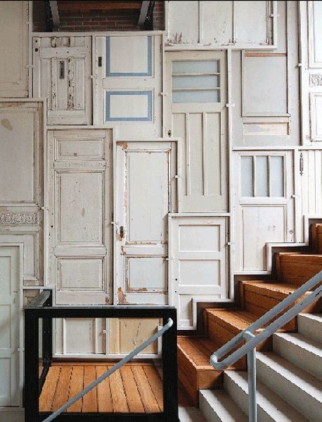 the stairs are lined with white doors and wooden steps