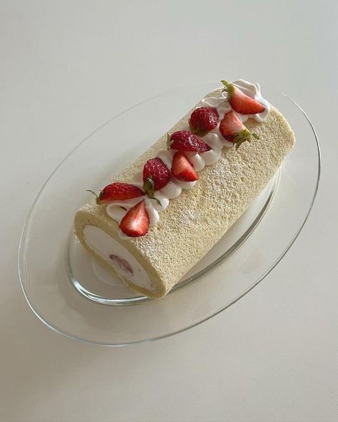 a cake with strawberries on it sitting on a glass plate