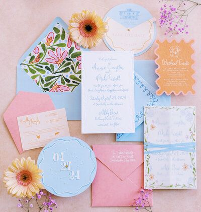 the wedding stationery is laid out on top of each other, including envelopes and cards