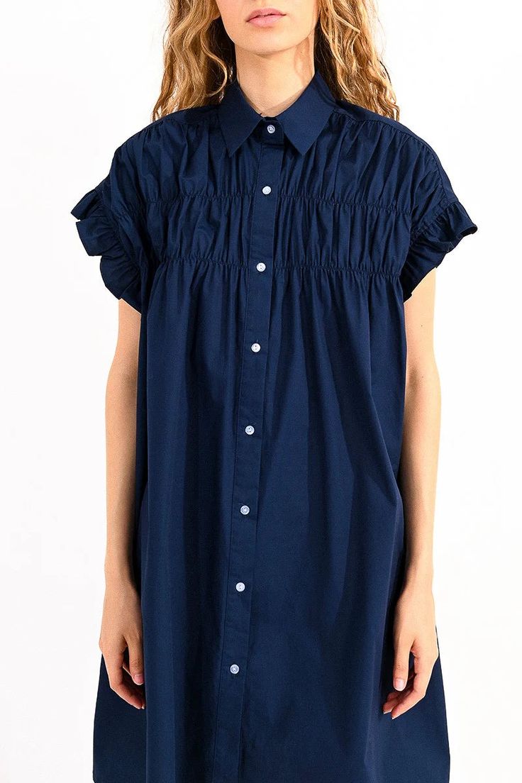 This Gathered Shirt Dress in Navy is all about playful, flirty style. The pointed collar and front button closure elevate the classic shirt dress silhouette. Elasticated ruffled armholes add a touch of whimsy, while the bust gathers create a flattering fit. Perfect for a fun day out (and maybe a twirl or two)! Length : 91cm for Size Small Classic Shirt Dress, Cotton Shirt Dress, Fun Color, Color Dress, Dress Silhouette, Button Down Dress, Swimwear Sale, Navy Blue Dresses, Fashion Mode