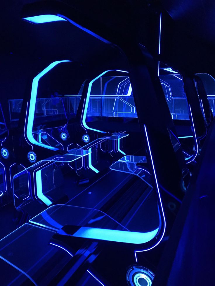 the interior of a futuristic vehicle with neon lights and blue lighting on the seats is lit up