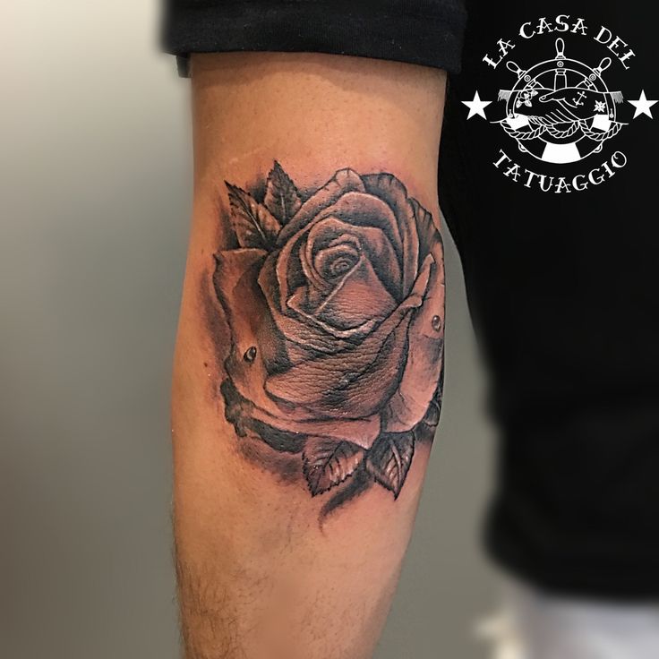 a man with a rose tattoo on his arm