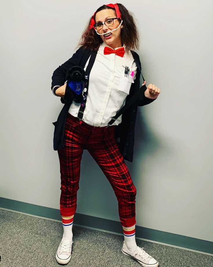 a woman in plaid pants and bow tie posing for the camera with her hands on her hips