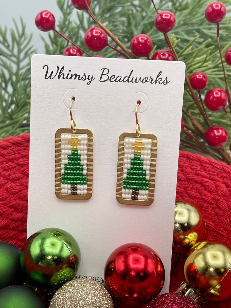 Introducing our fabulous and festive Christmas Tree Earrings. Hand beaded using premium seed beads and golden brass accents, these playful and gorgeous earrings add an extra touch of charm to your holiday ensemble. The perfect gift option, these eye-catching earrings make for an ideal stocking stuffer or a thoughtful present for a loved one. With these festive holiday earrings, you're sure to make a statement and spread joy wherever you go! Choice of with bow or without ✔️1 5/8 inches long & 5/8 Tree Earrings, Holiday Earrings, Christmas Tree Earrings, Holiday Earring, Earring Tree, Brass Accents, Festive Holiday, Gorgeous Earrings, Hand Beading