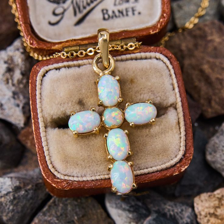 This lovely cross pendant features five oval and one round cabochon cut lab created opals in four prong settings. The pendant necklace is crafted in 14k yellow gold and hangs from a14k yellow gold, 18 inch long cable chain. The bail has a Czechoslovakian stamp. Opal Cross Necklace, Vintage Yellow Gold Cross Pendant Necklace, Spiritual Yellow Gold Opal Necklace, Yellow Gold Hallmarked Cross Pendant, Tarnish-resistant Yellow Gold Cross Pendant, Cross Pendant Necklace, Cable Chain, Cross Pendant, Prong Setting