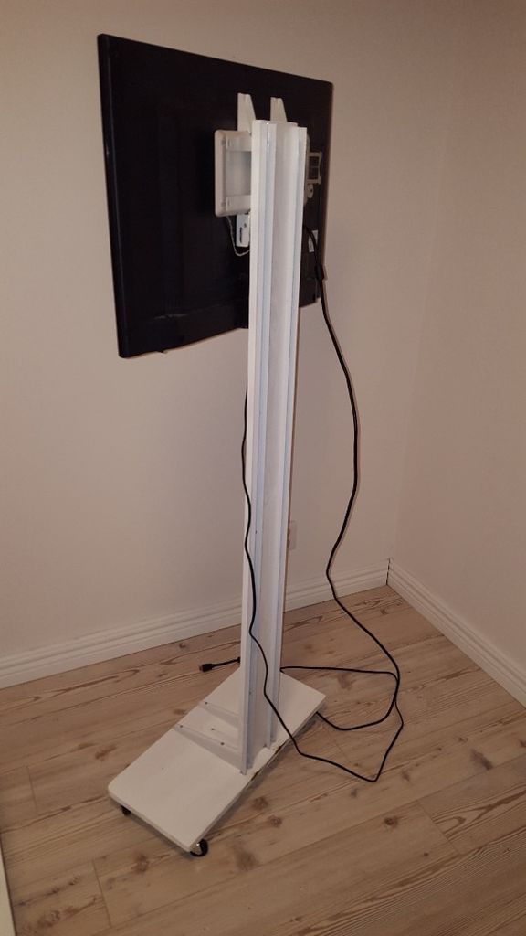 a flat screen tv sitting on top of a wooden floor next to a white wall