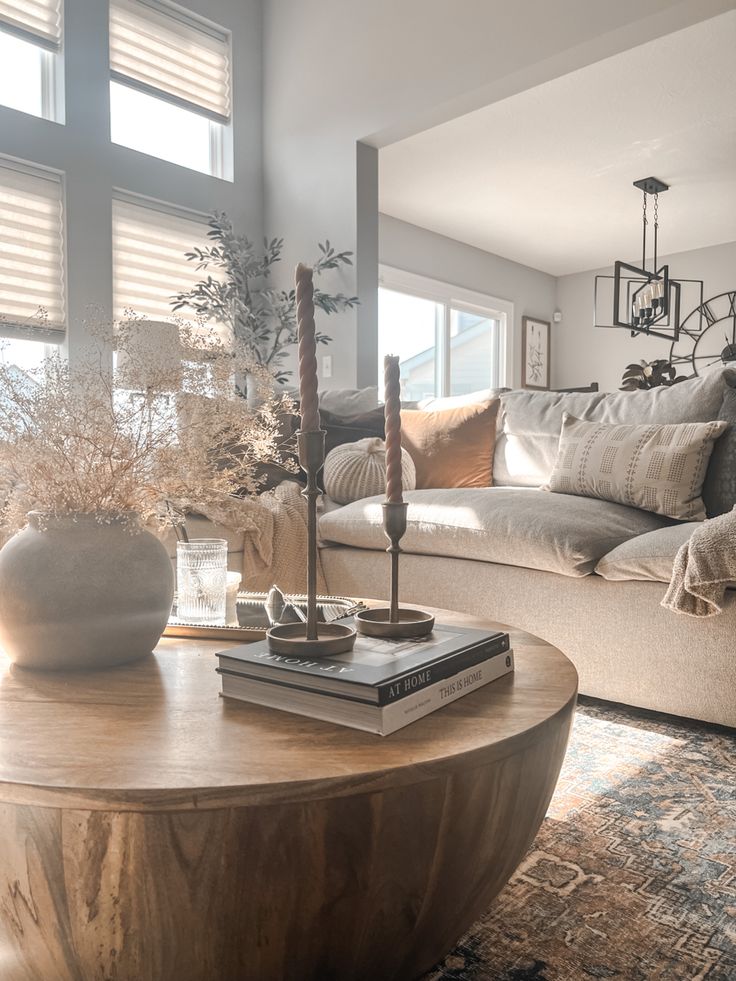 a living room filled with furniture and a coffee table in front of a large window