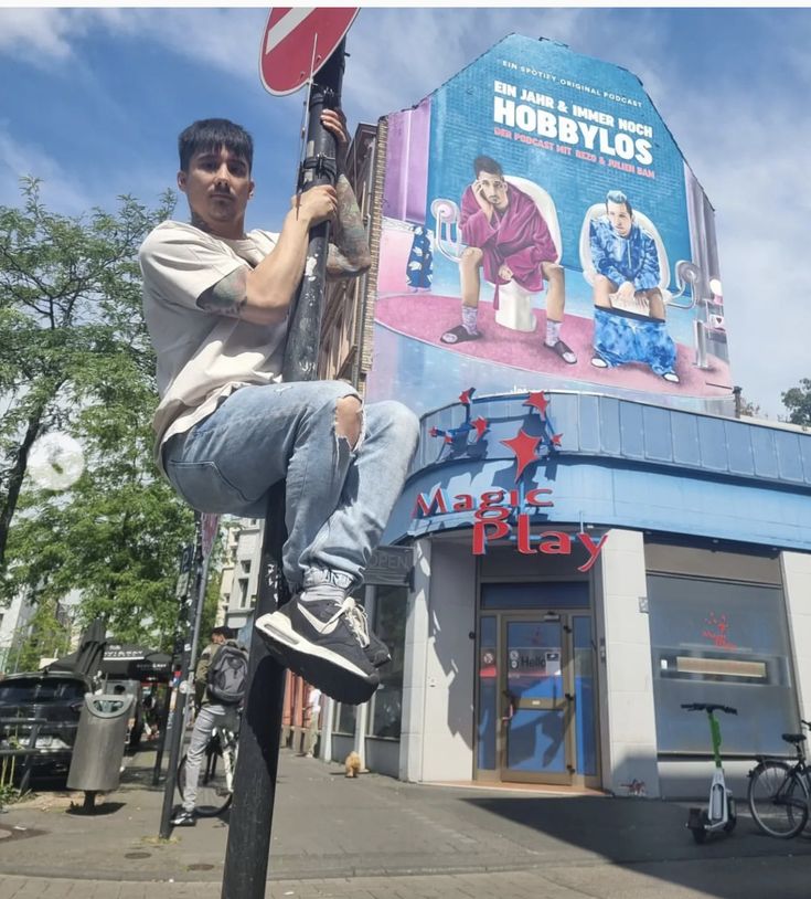 a man sitting on top of a pole in front of a building