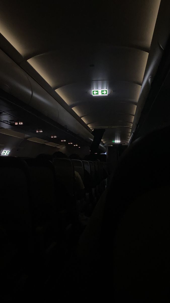 the inside of an airplane with lights on and no people sitting in it at night